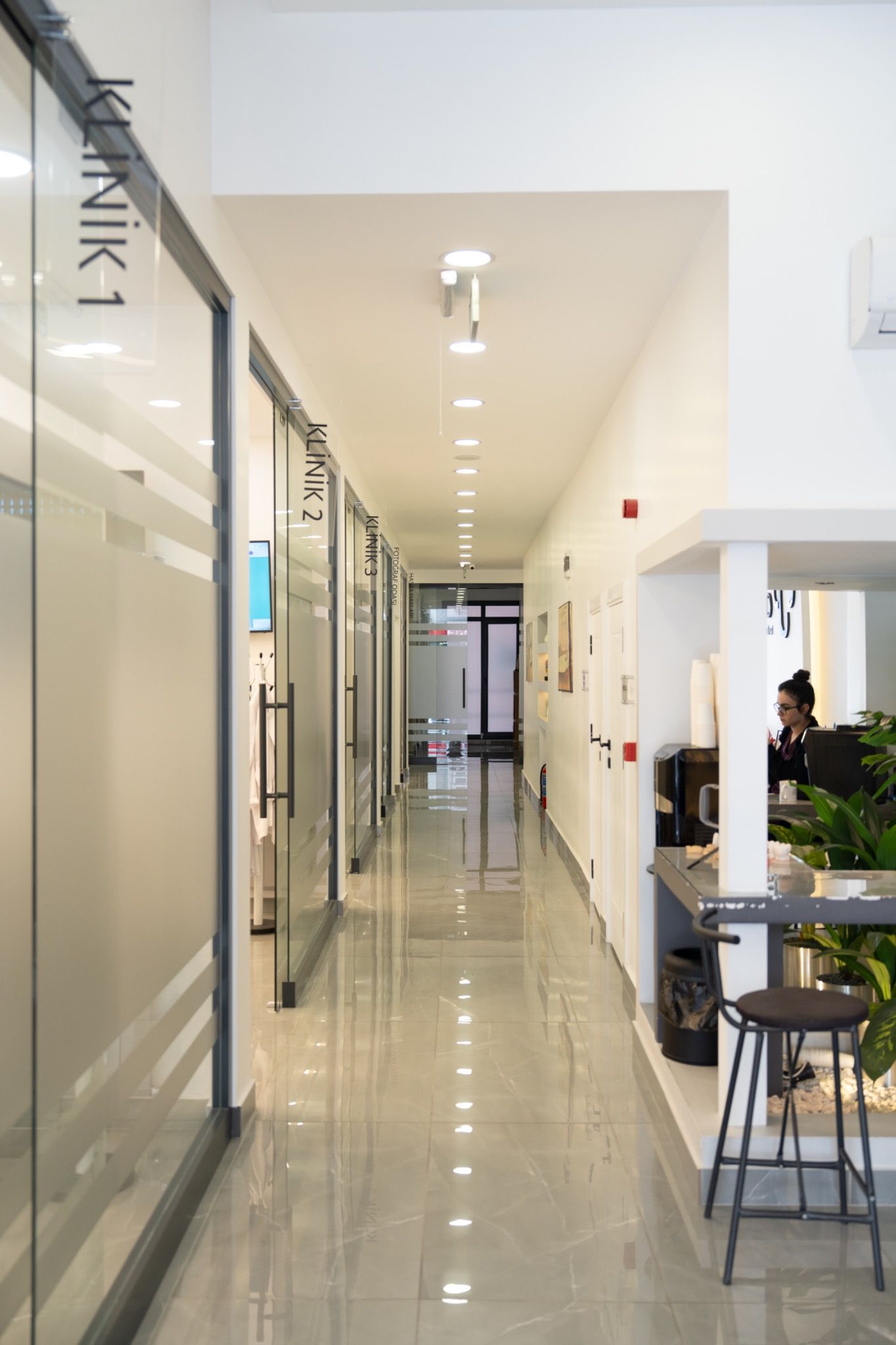 A corridor lined with glass-walled treatment rooms.