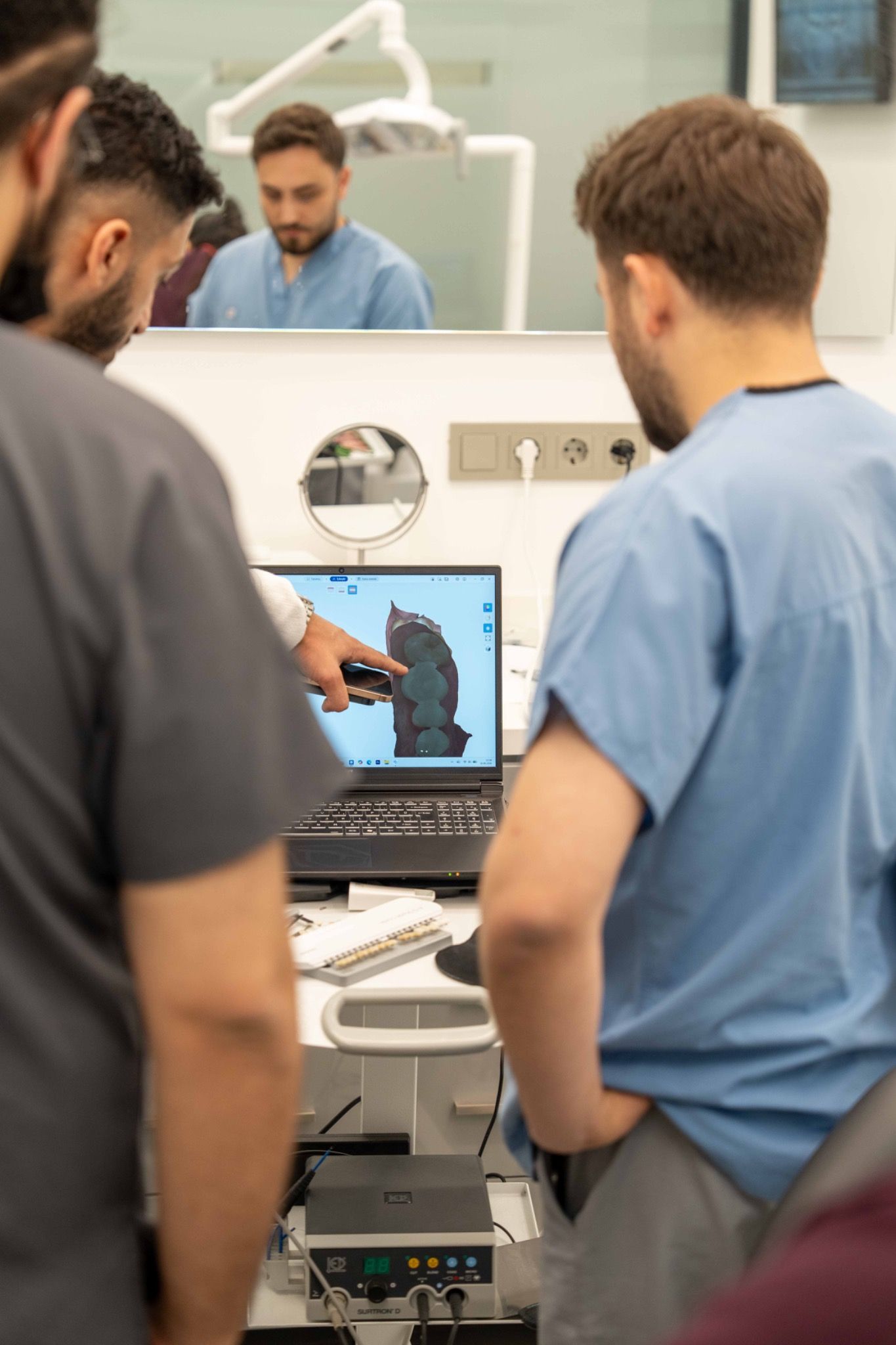 Two dentists reviewing a digital model on a laptop.