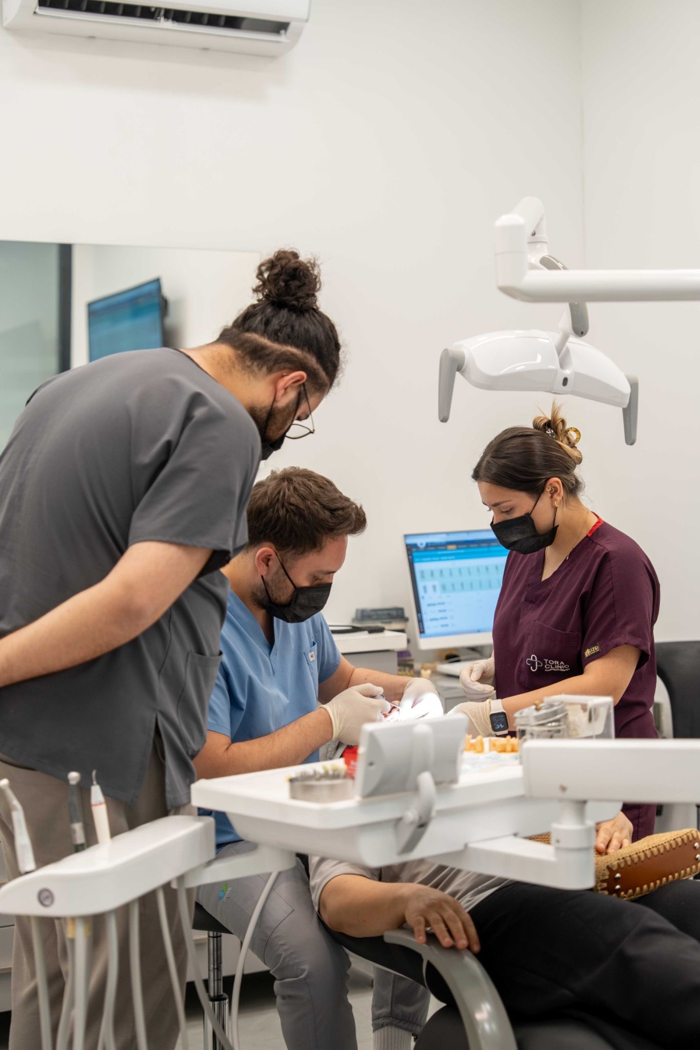 Several members of the team at work around a treatment chair.