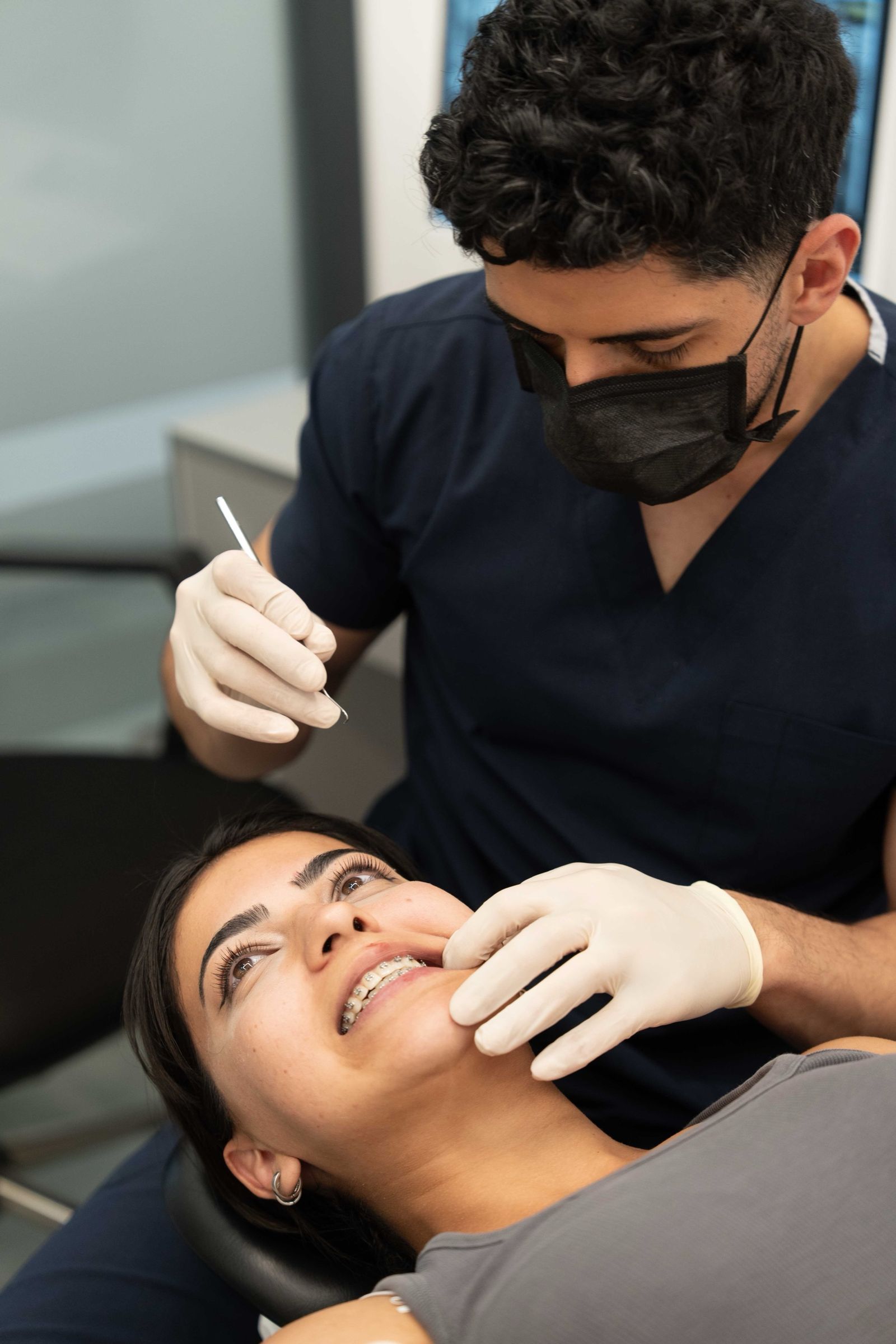A dentist examining a patient wearing braces.