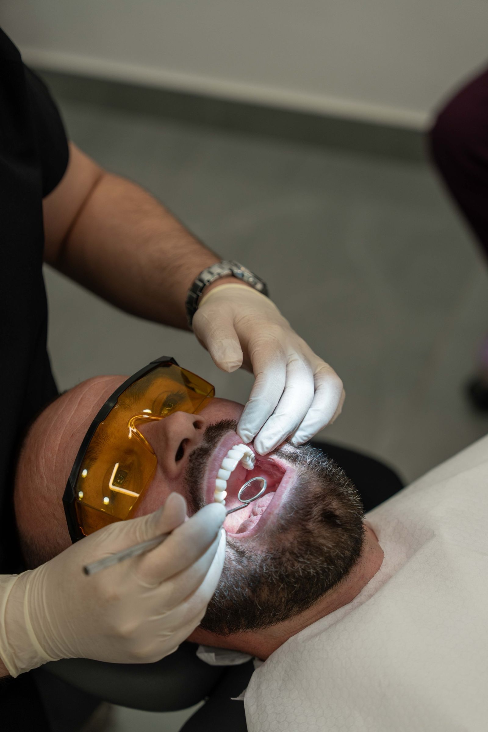 A dentist checking a patient’s front teeth at the treatment chair.