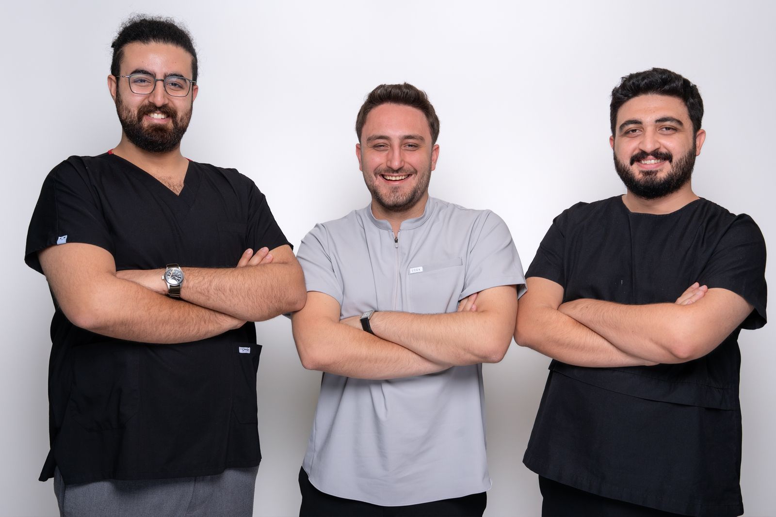 The three founding doctors of TORA Clinic standing side by side, arms crossed.